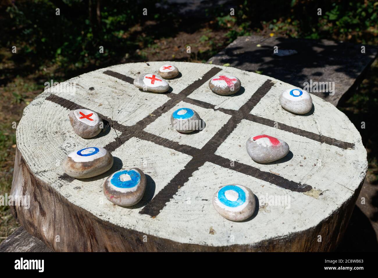 Wood and stone outdoor game of noughts and crosses or tic tac toe. Stock Photo