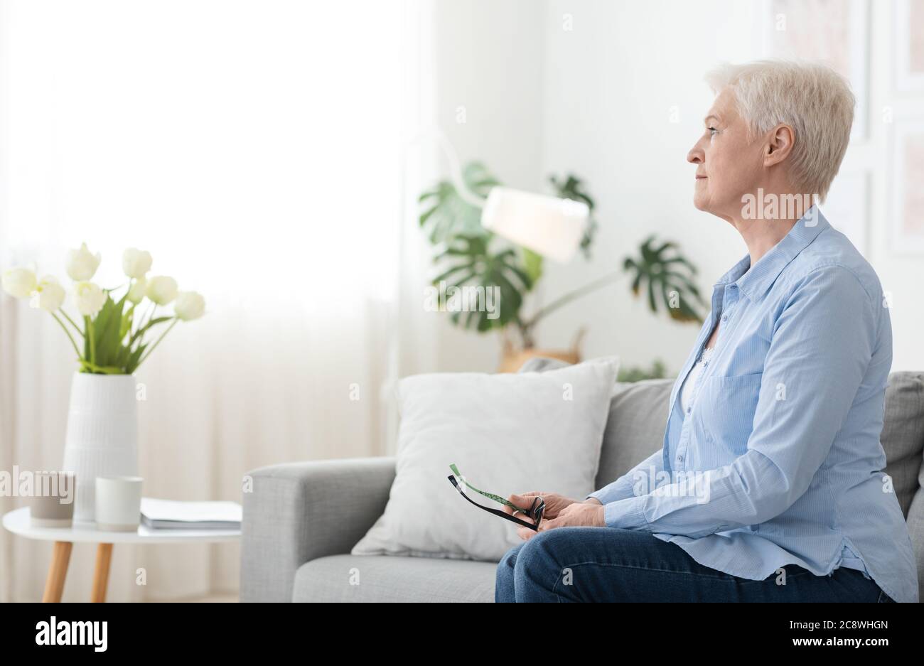 Old woman sitting alone sofa hi-res stock photography and images - Alamy