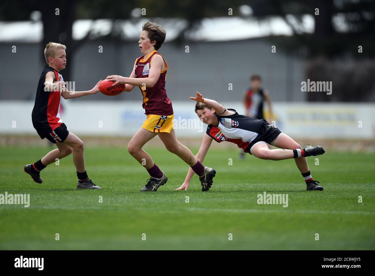 A Wangaratta Imps player makes a run for it during a junior grass roots football final at Wangaratta Oval North East Victoria. Stock Photo