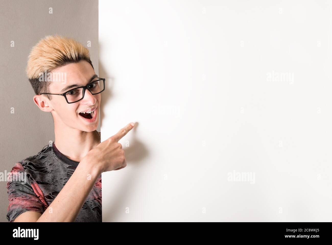 Young boy pointing to a white panel Stock Photo