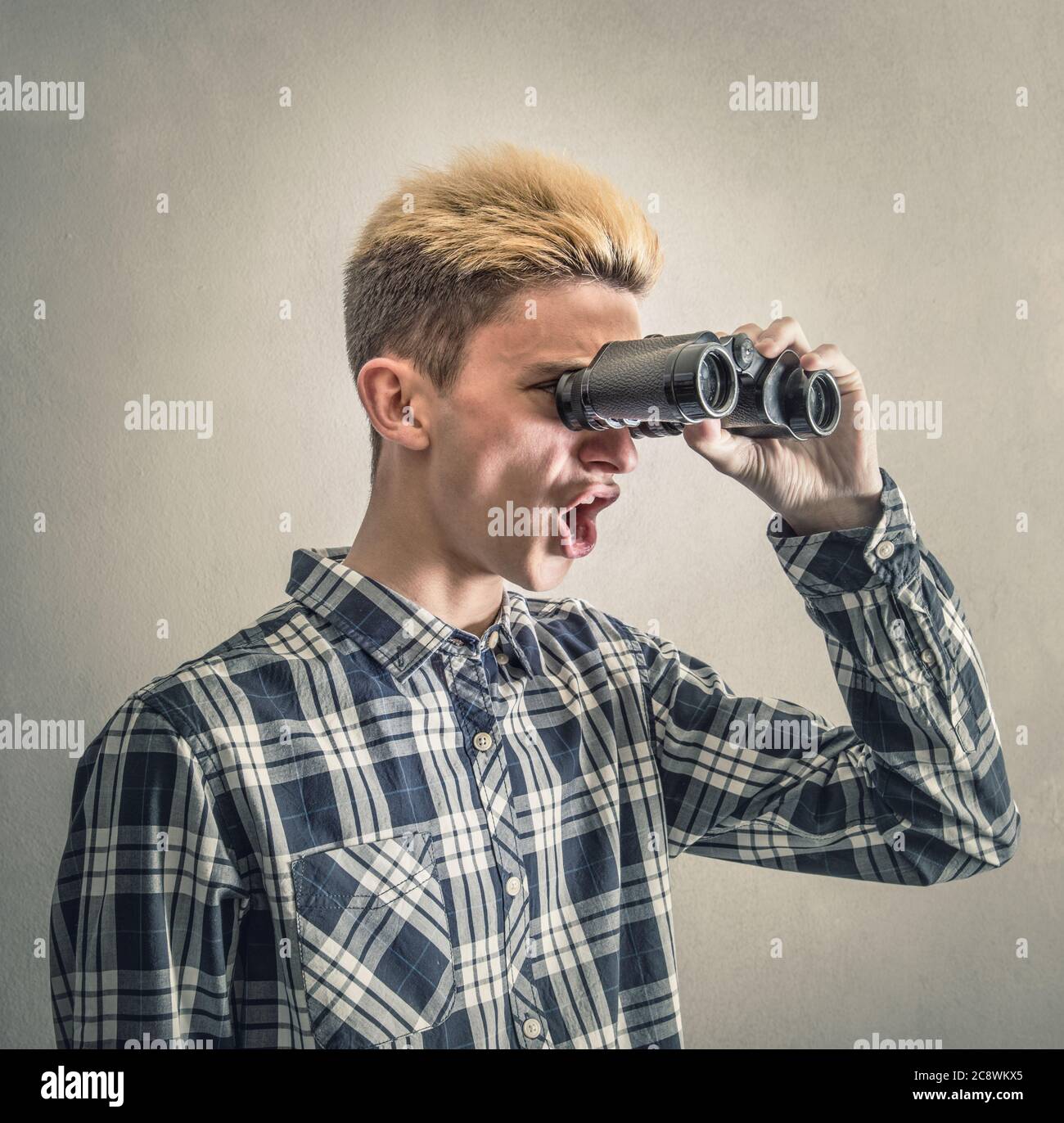 Young man looking through binoculars Stock Photo
