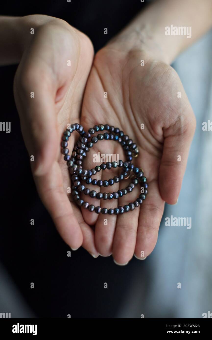 Woman Holding Black Pearl Necklace Stock Photo