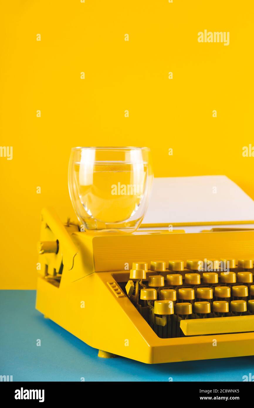 Yellow bright typewriter on a yellow background. Creativity concept