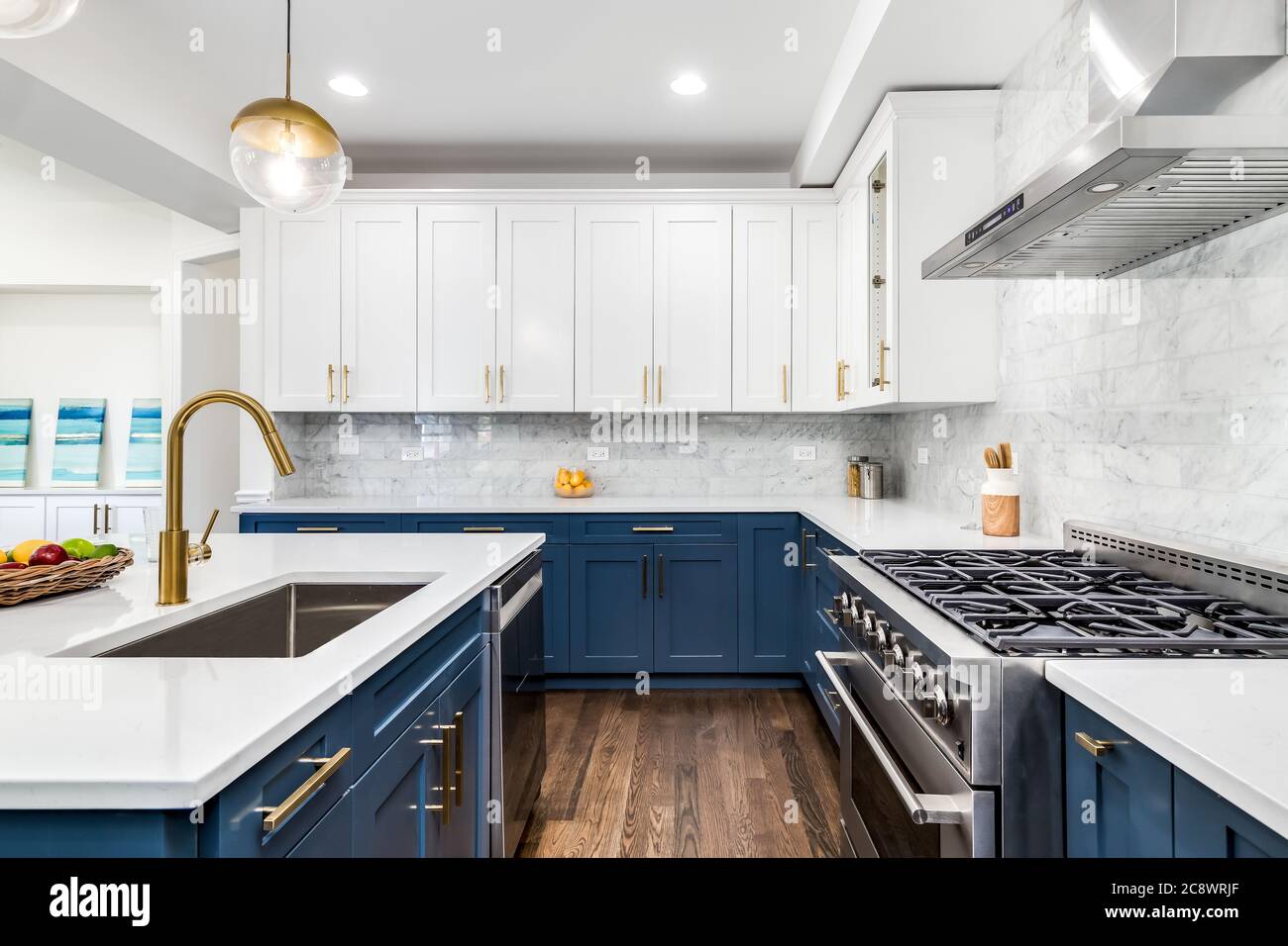 A luxurious white and blue kitchen with gold hardware, Bosch and