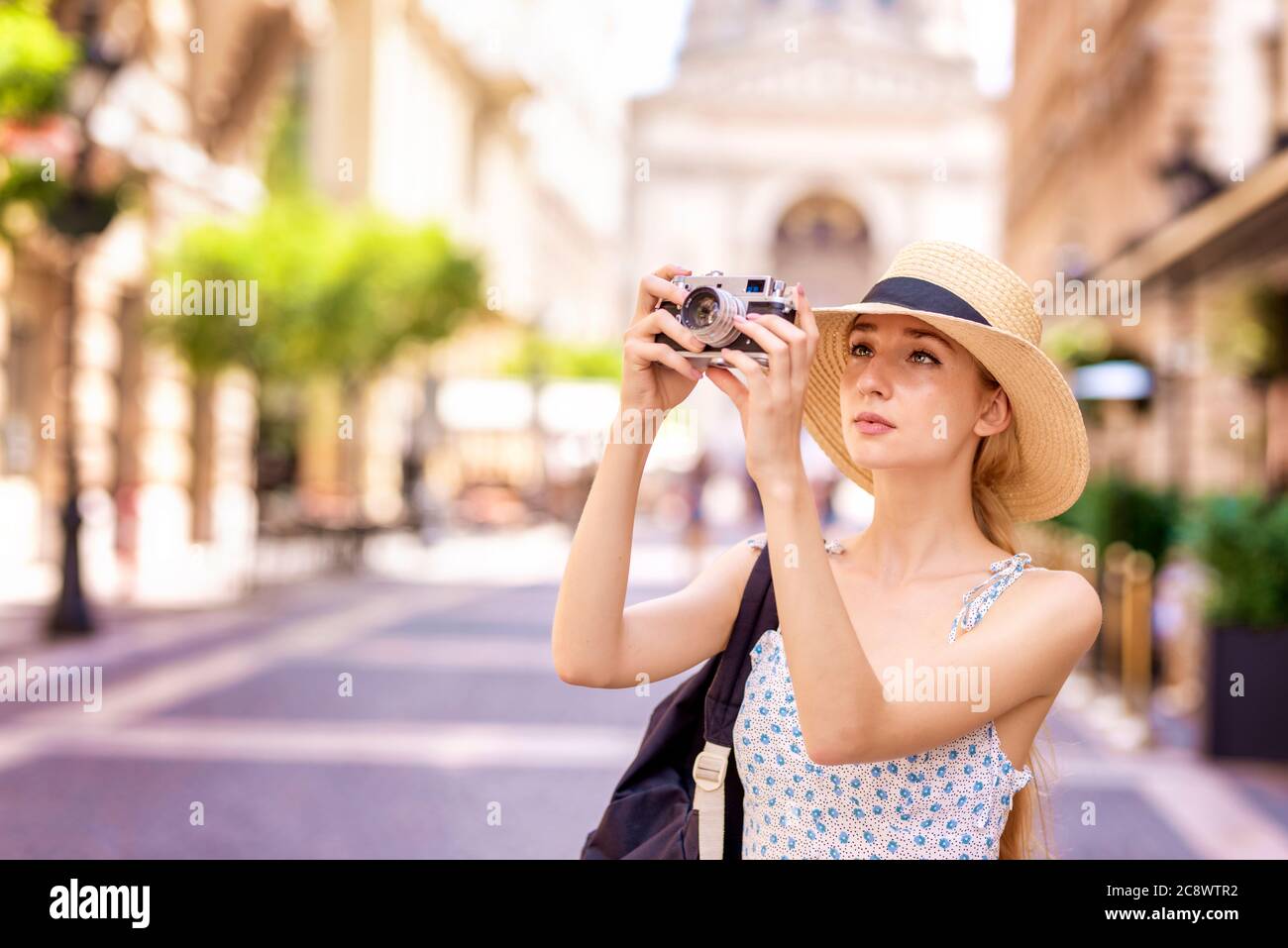 Shot of young woman taking pictures with vintage camera while ...