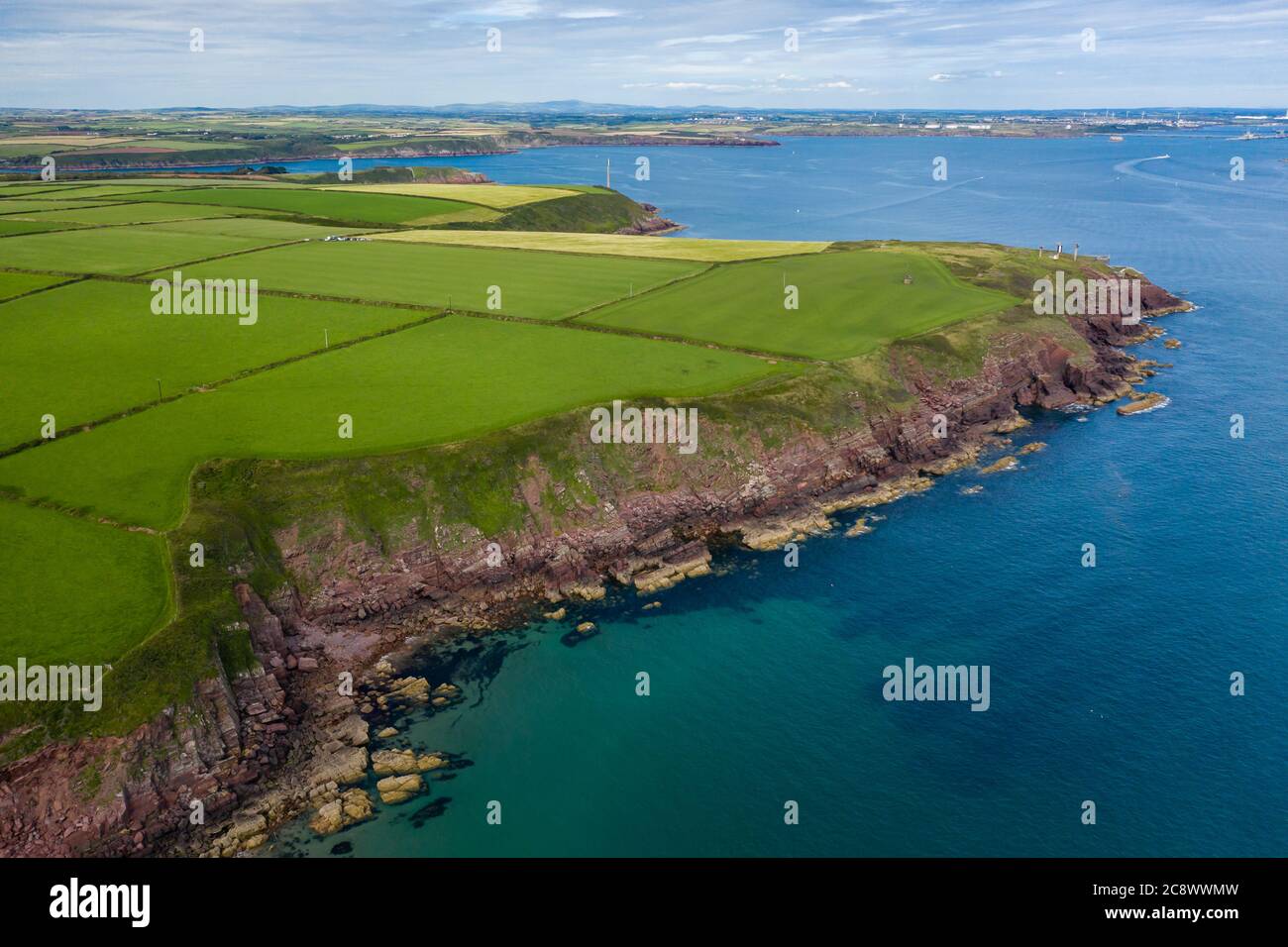 Aerial view of farms and fields on clifftops next to the ocean (Milford