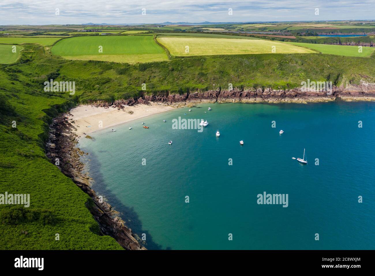 Aerial view of a small, sandy beach in a rocky bay (Watwick Bay, Milford Haven, Wales) Stock Photo