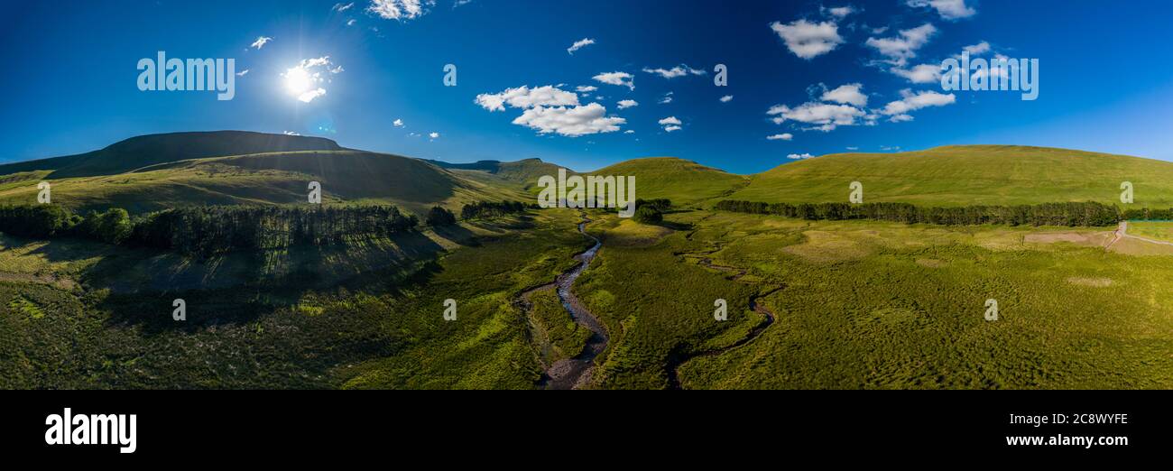 Panoramic aerial view of a small river running from distant mountains ...