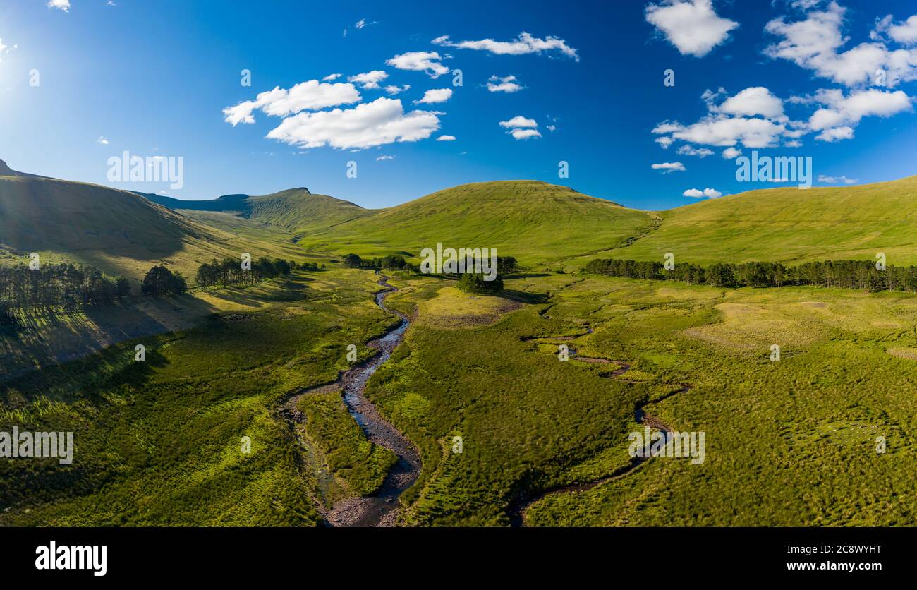 Panoramic aerial view of a small river running from distant mountains ...