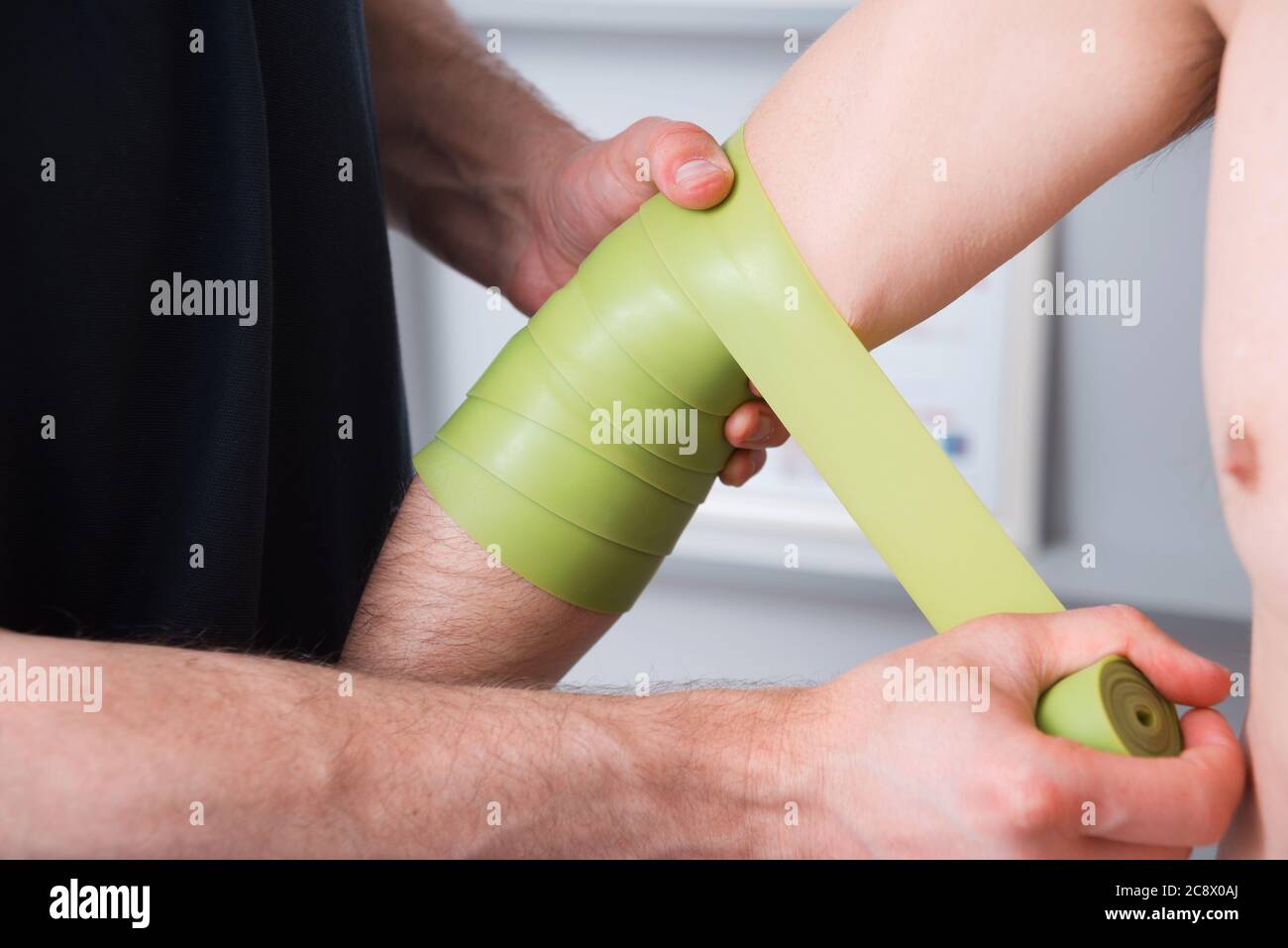 Elbow pain therapy with kinesio green tape Stock Photo Alamy