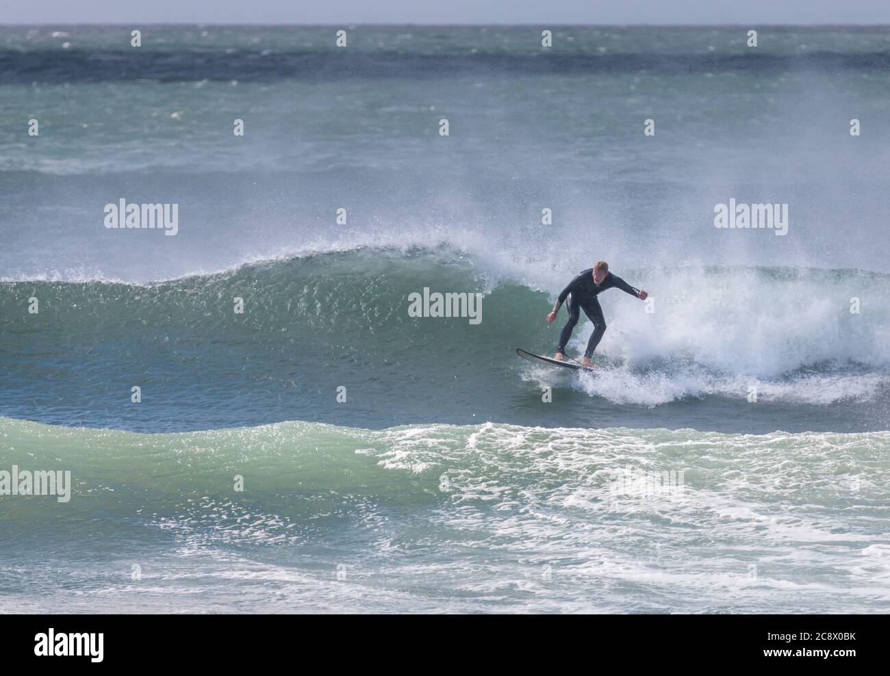 Garrettstown, Cork, Ireland. 27th July, 2020.A surfer rides the wave in turbulent storm like conditions at Garrettstown, Co. Cork, Ireland. - Credit; David Creedon / Alamy Live News Stock Photo
