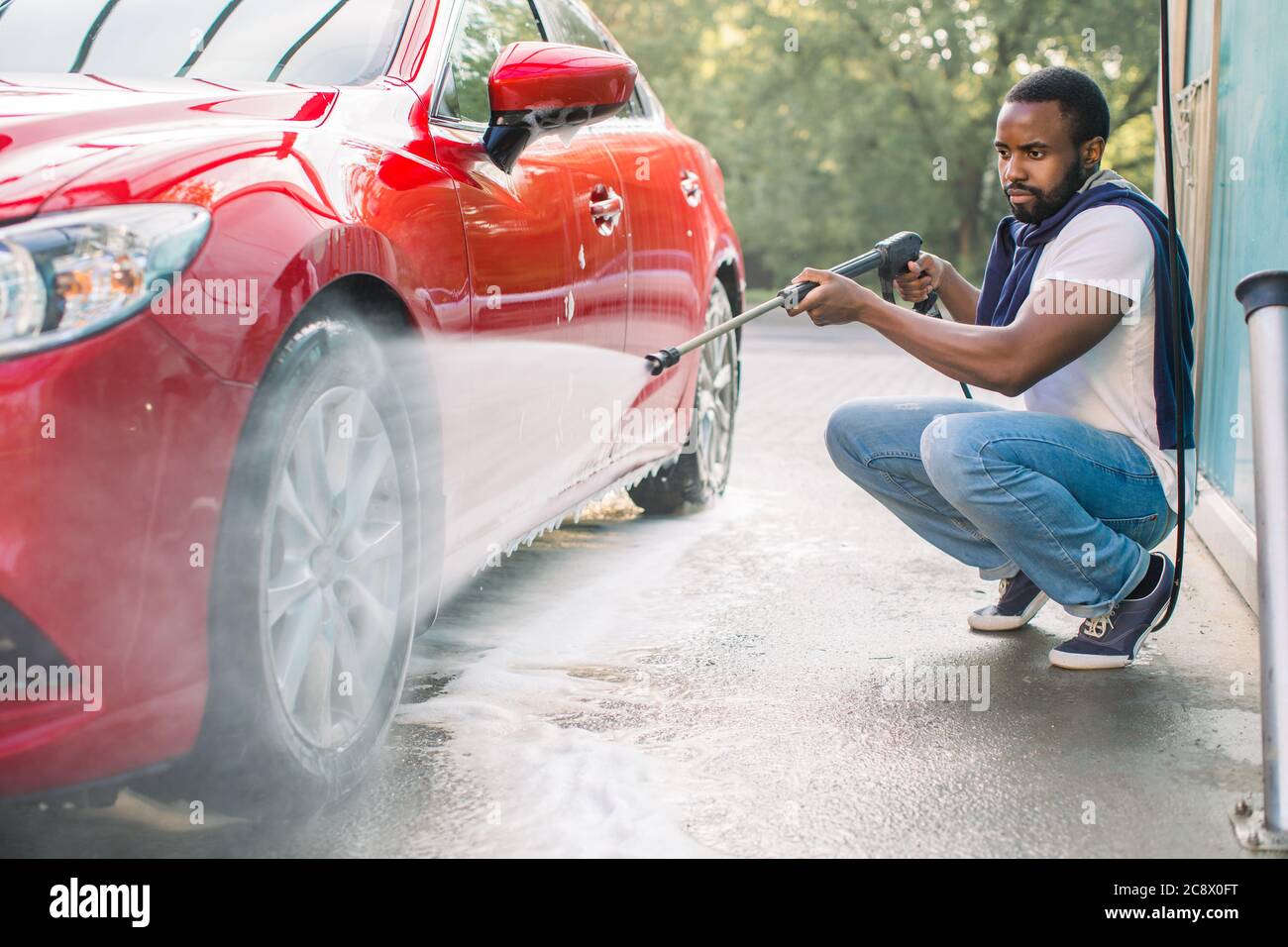halvleder bagage Tips Car wheel, rim or alloy, wash outdoors. Car cleaning with water jet.  Horizontal shot of pleasant African guy in white t-shirt and jeans, washing  his Stock Photo - Alamy