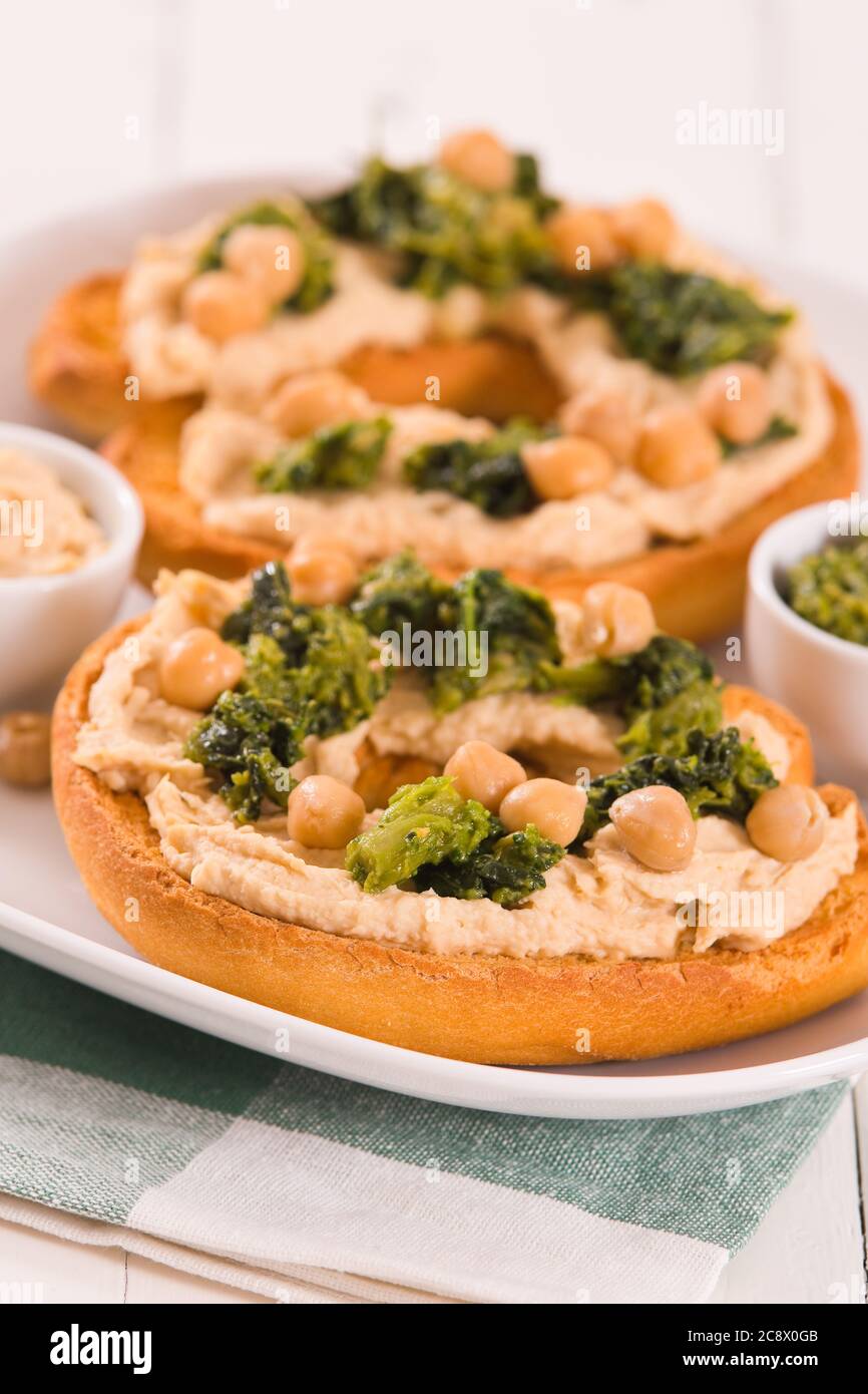 Friselle with turnip tops and hummus. Stock Photo