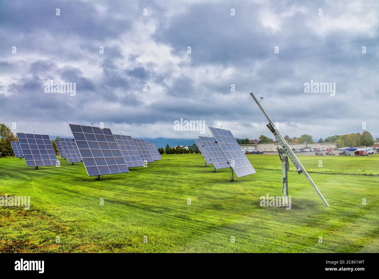 Solar panels at sunrise with cloudy sky in the countryside. Solar energy, modern electric power production technology, renewable energy concept. Envir Stock Photo