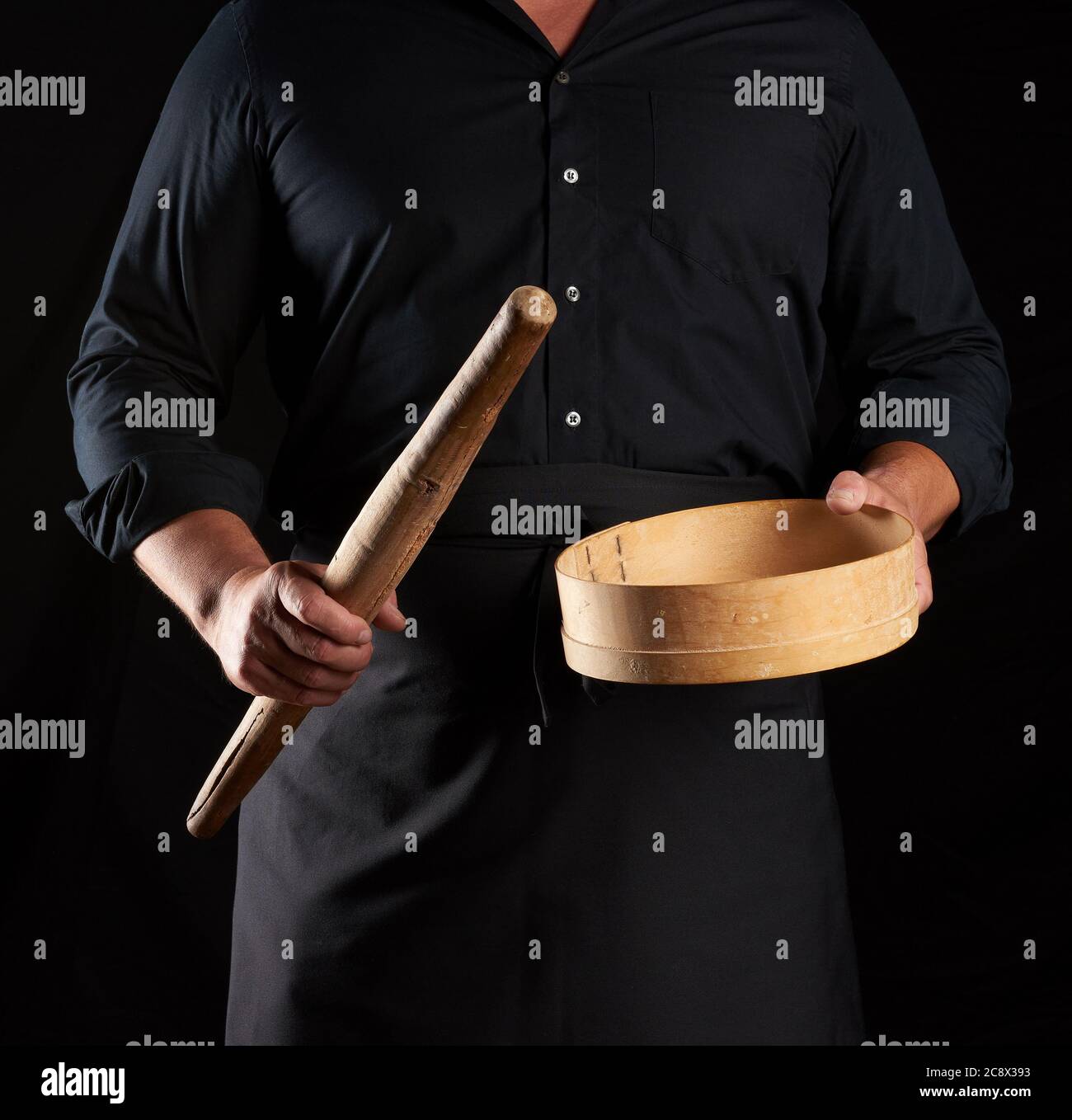 man in black uniform holding empty vintage round wooden sieve for ...