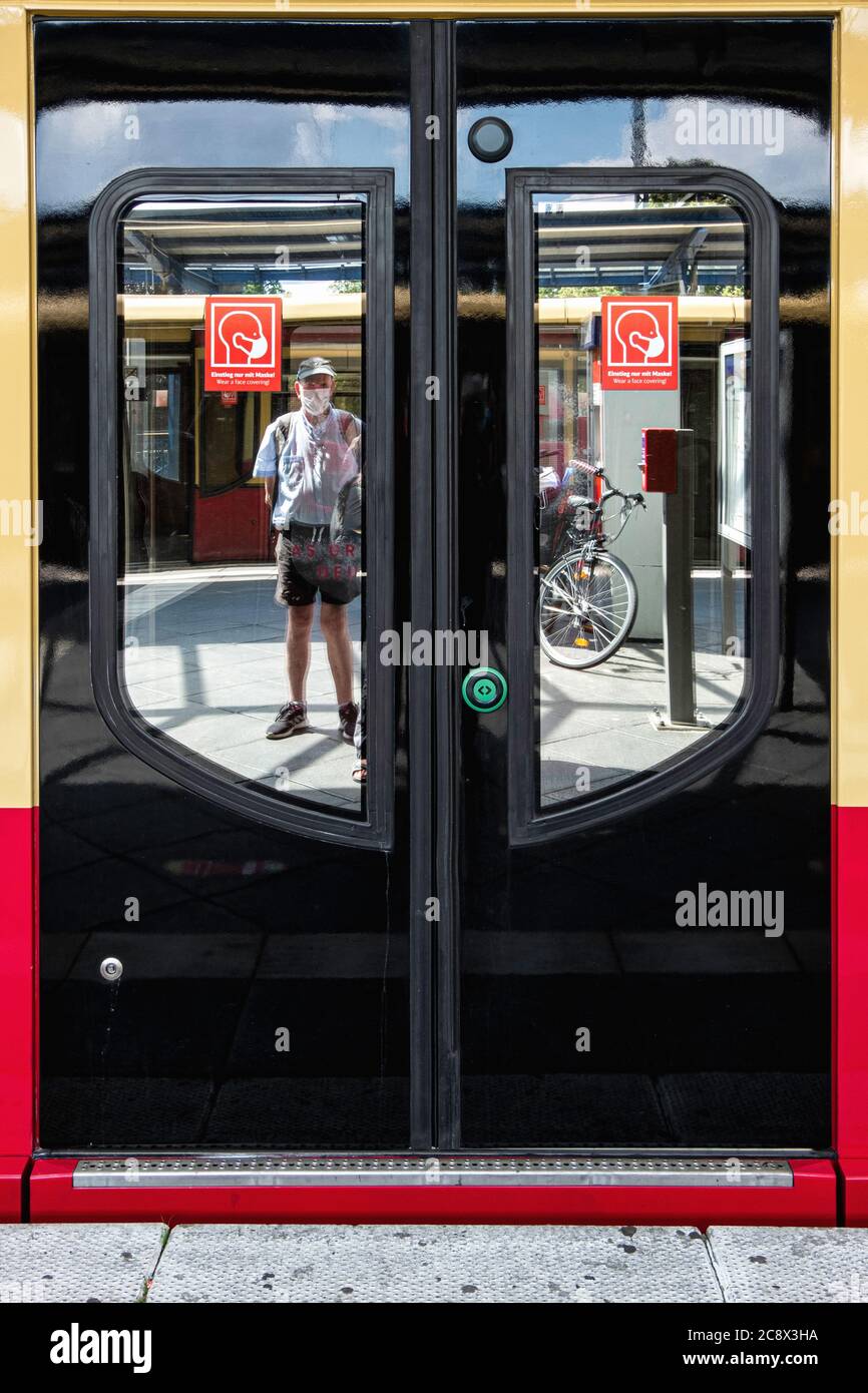 Man wearing a face mask and wear a face mask sign on train door in