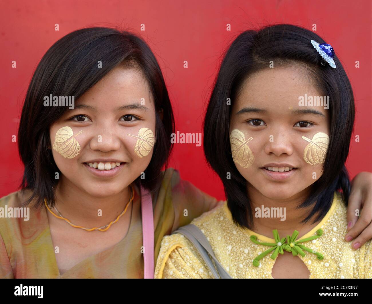 Two pretty Burmese teenage girls with leafshaped natural thanaka face
