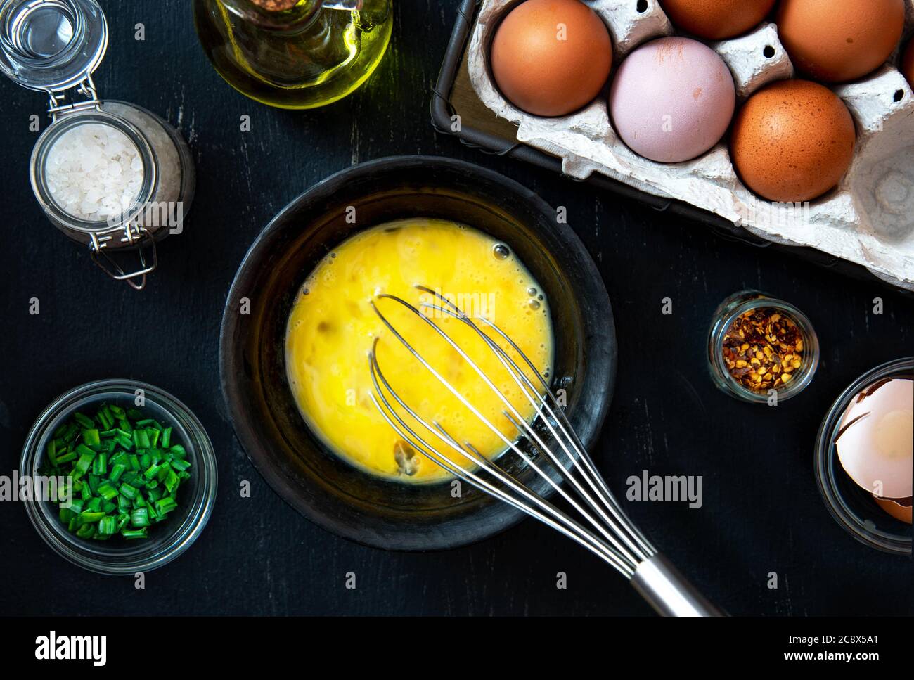 Beat eggs in a bowl, and ingredients for making an omelette with green