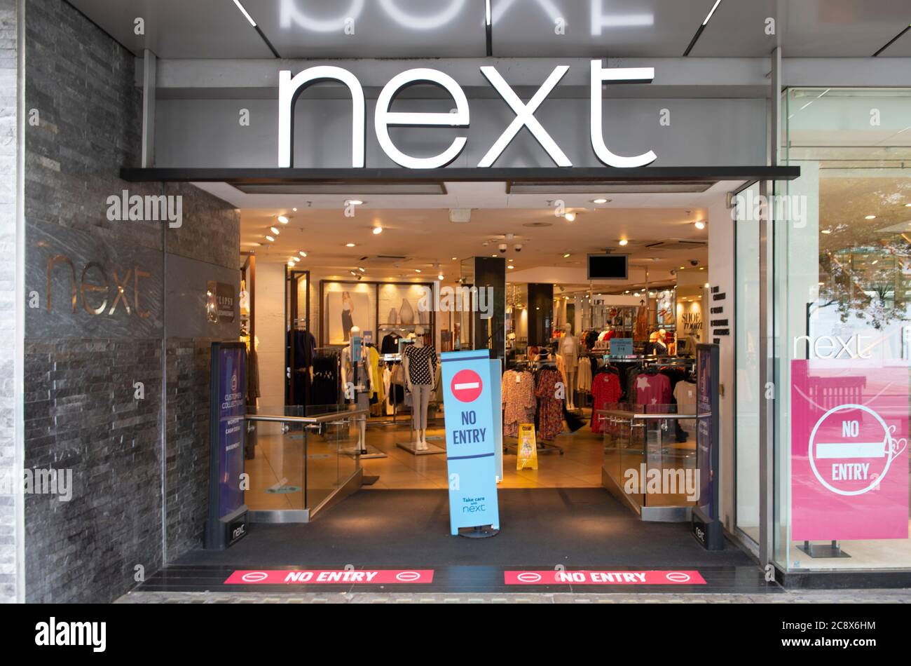 Oxford Street, London, UK. 27 July 2020. Central London shopping streets remain quiet on a grey Monday morning. Next store in Oxford Street operating a one way entry-exit system. Credit: Malcolm Park/Alamy Live News. Stock Photo