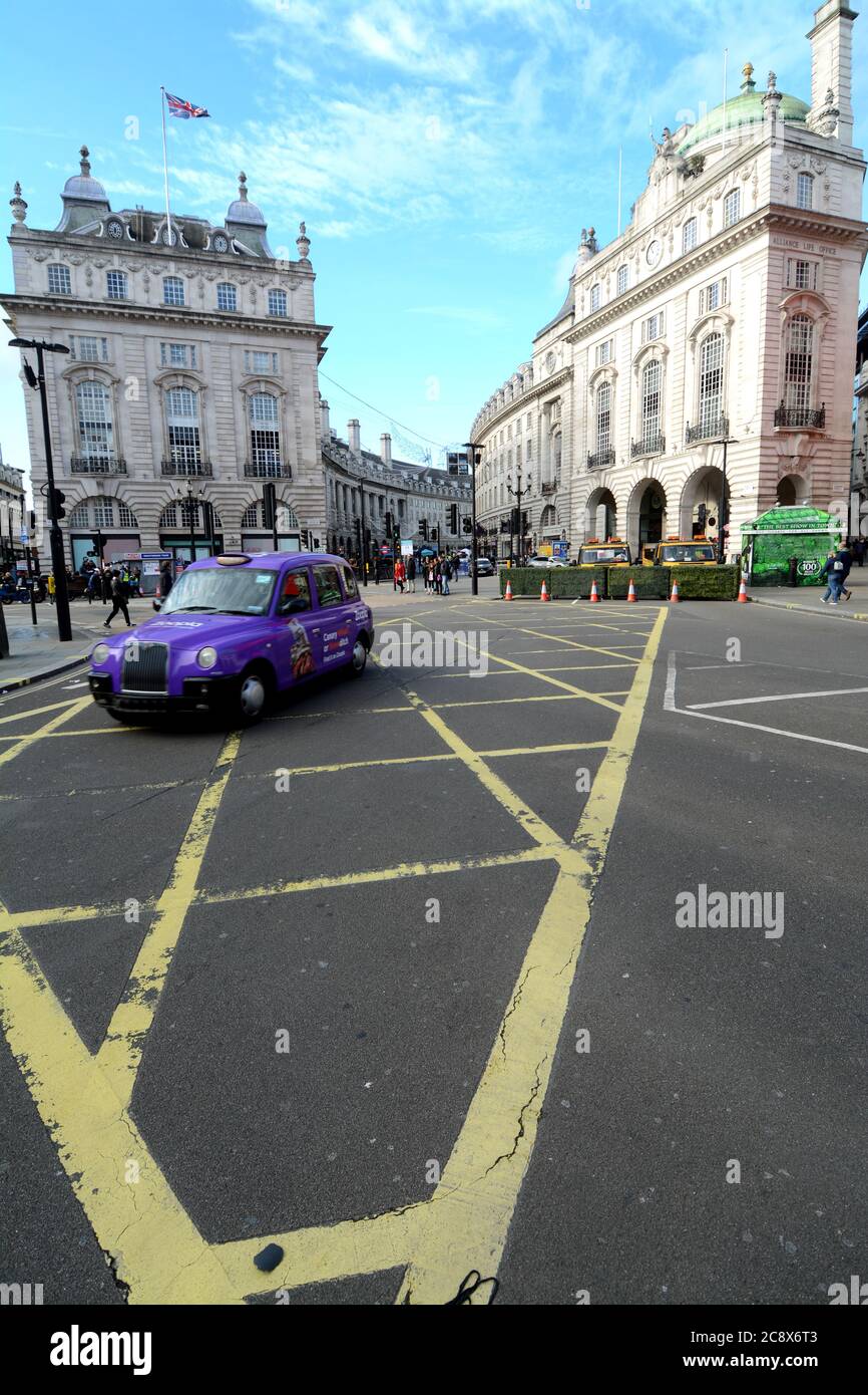 Piccadilly Circus is a symbolic London square full of traffic, people, taxis and red buses. Stock Photo