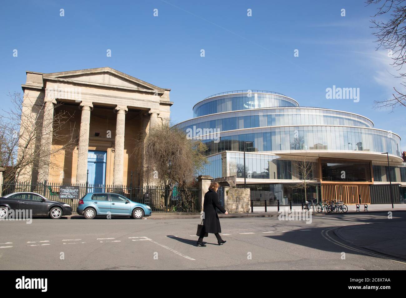 Three cyclistspassing the contrasting architecture of Freud's cafe and the Blavatnik school of government on Walton Street Oxford Stock Photo