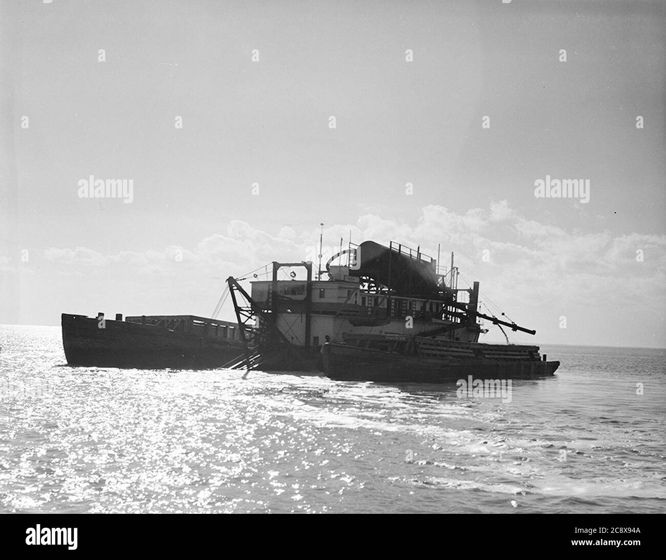 Dredge filling two barges with oysters hires stock photography and