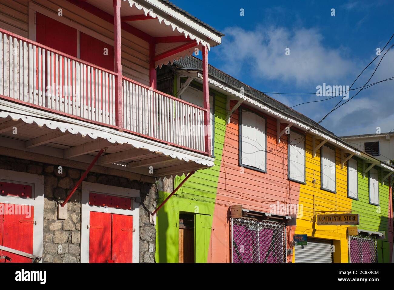 Pretty veranda on a house with white railings and shuttered windows in Roseau, Dominica island, The Caribbean Stock Photo