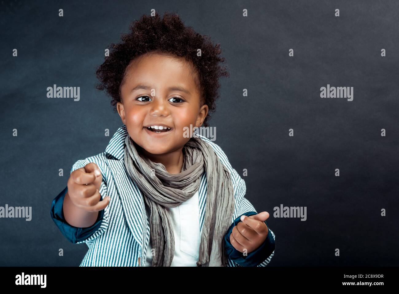 Studio Portrait of a Stylish Little African Boy with Curly Hair Isolated on  Dark Background. Kids Fashion. Kids Clothes Stock Photo - Alamy