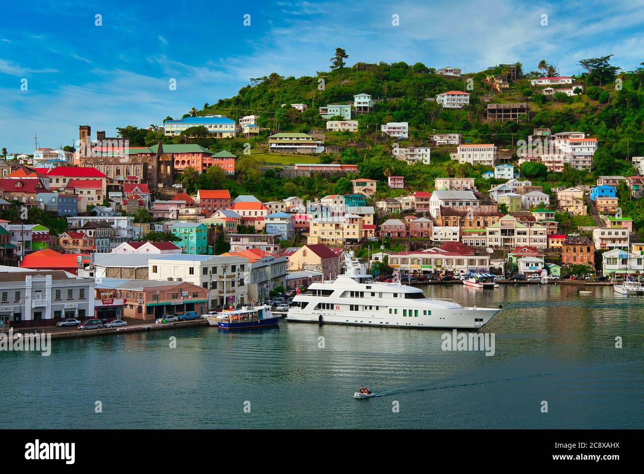 Overlooking the harbour and waterfront of St George's with small boats moored and houses on the hillsides beyond, Grenada island, The Caribbean Stock Photo
