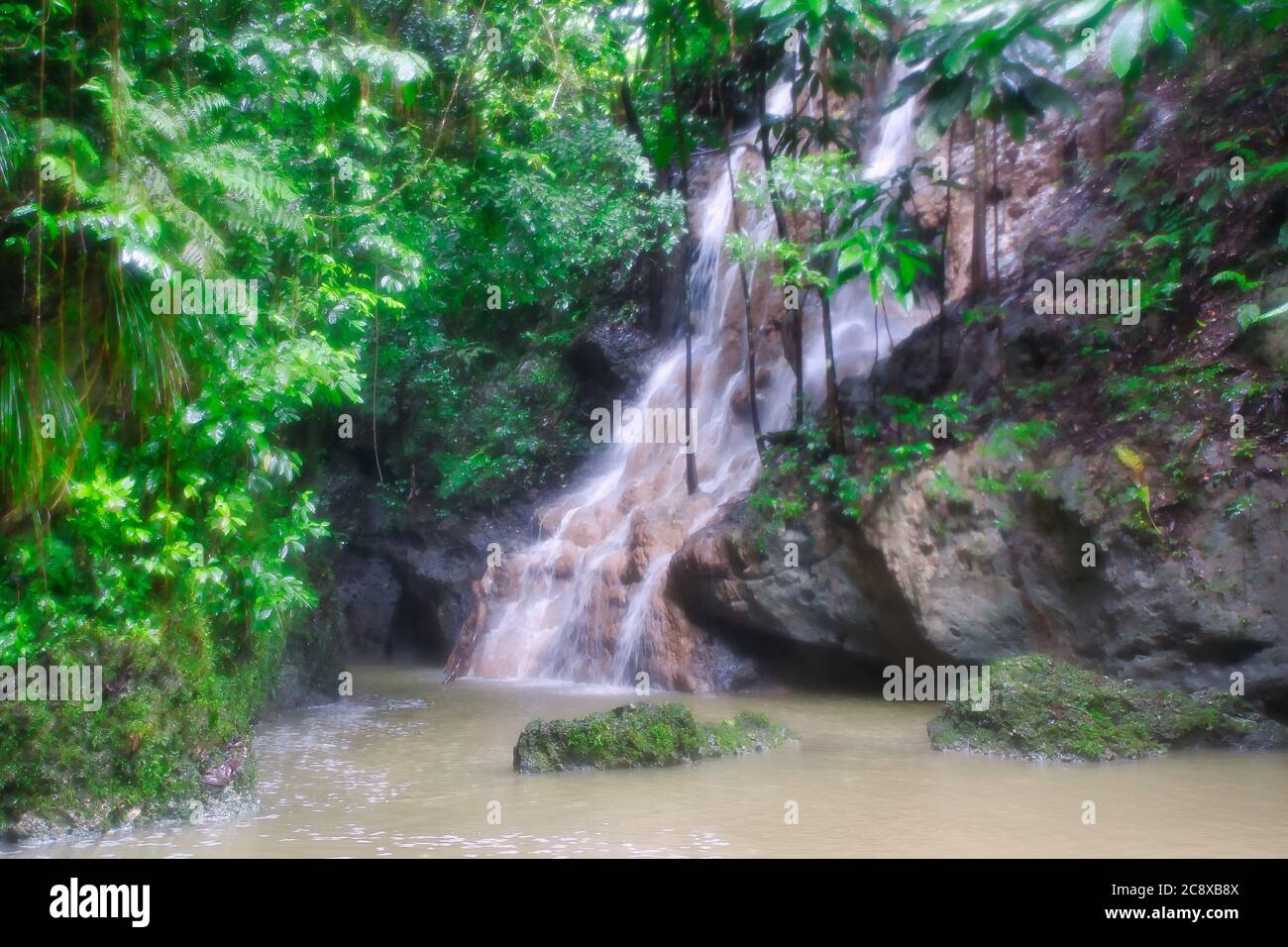 Pretty scene of a waterfall splashing down over rocks with a small lake