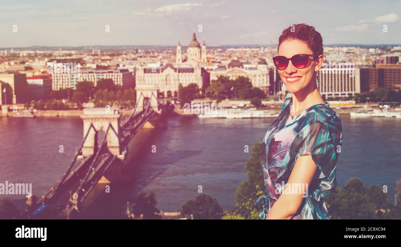 Happy young redhead Caucasian 20s woman toothy smile at Budapest panorama, cinematic style, Hungary Stock Photo
