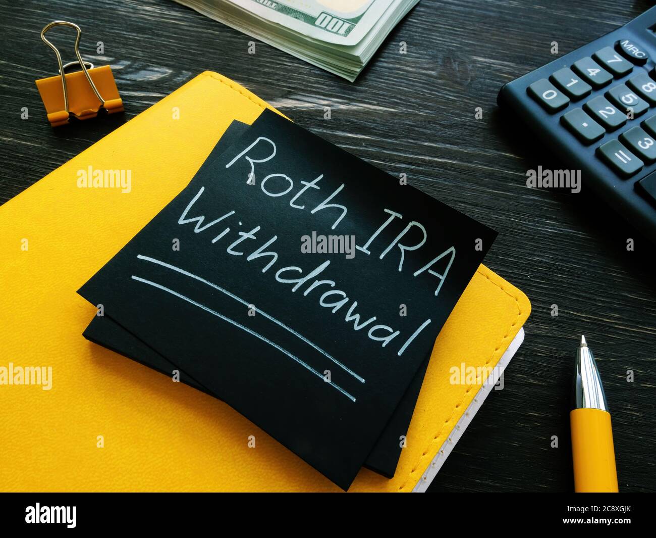 Roth IRA withdrawal words on a black page. Stock Photo