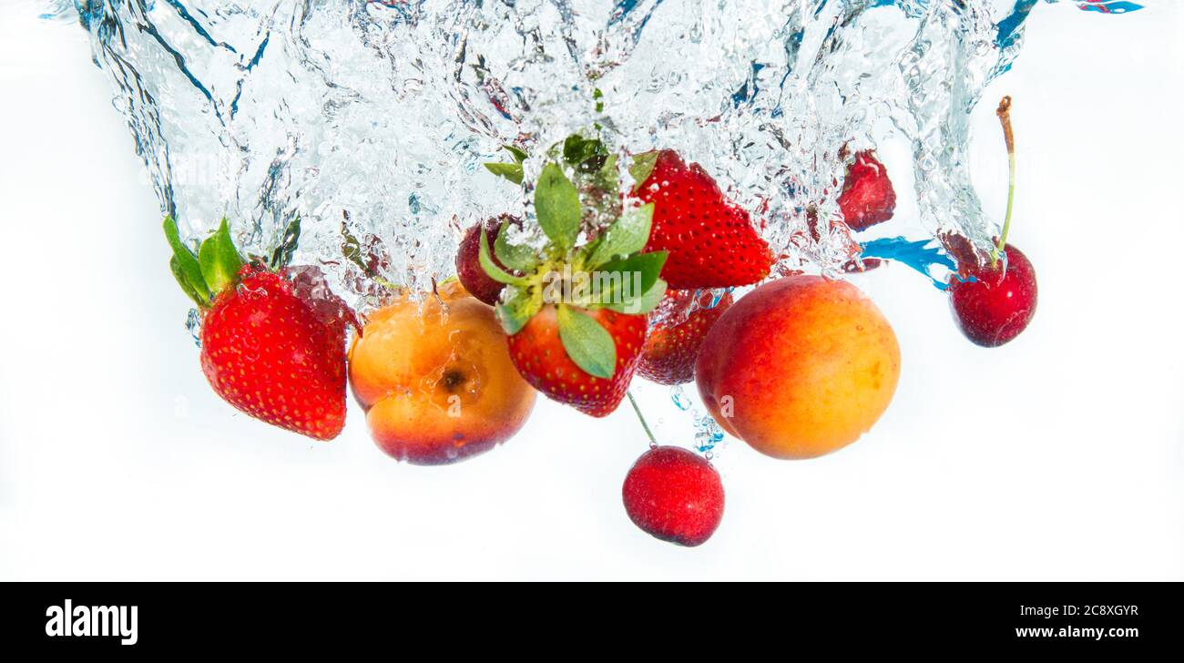 fresh fruits falling in water Stock Photo Alamy