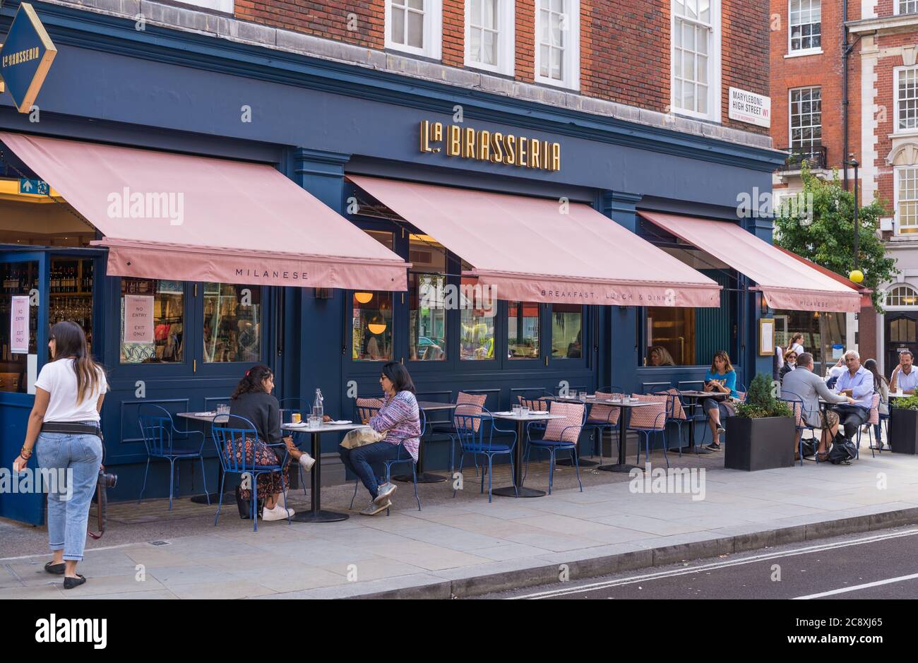 People dining al fresco at pavement tables at La Brasseria Milanese Italian restaurant in Marylebone High Street, London, England, UK Stock Photo