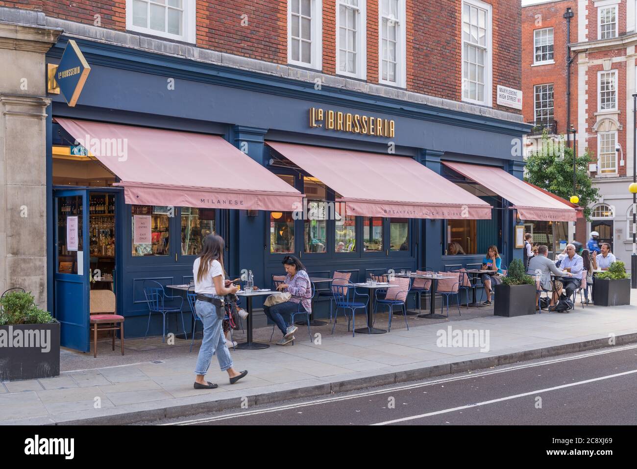 People dining al fresco at pavement tables at La Brasseria Milanese Italian restaurant in Marylebone High Street, London, England, UK Stock Photo