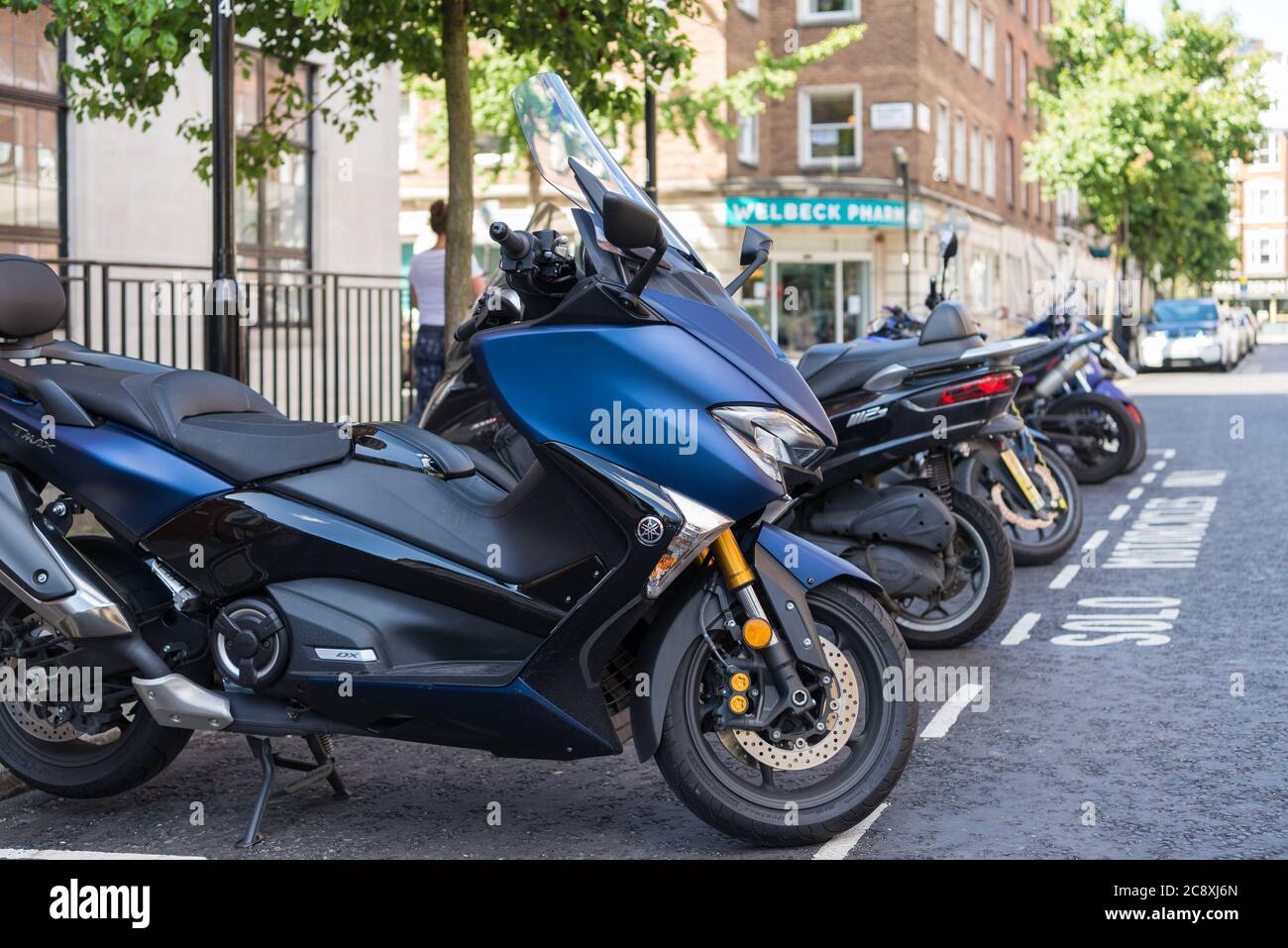 Motorbikes parked kerbside in a street parking bay, London, England, UK Stock Photo