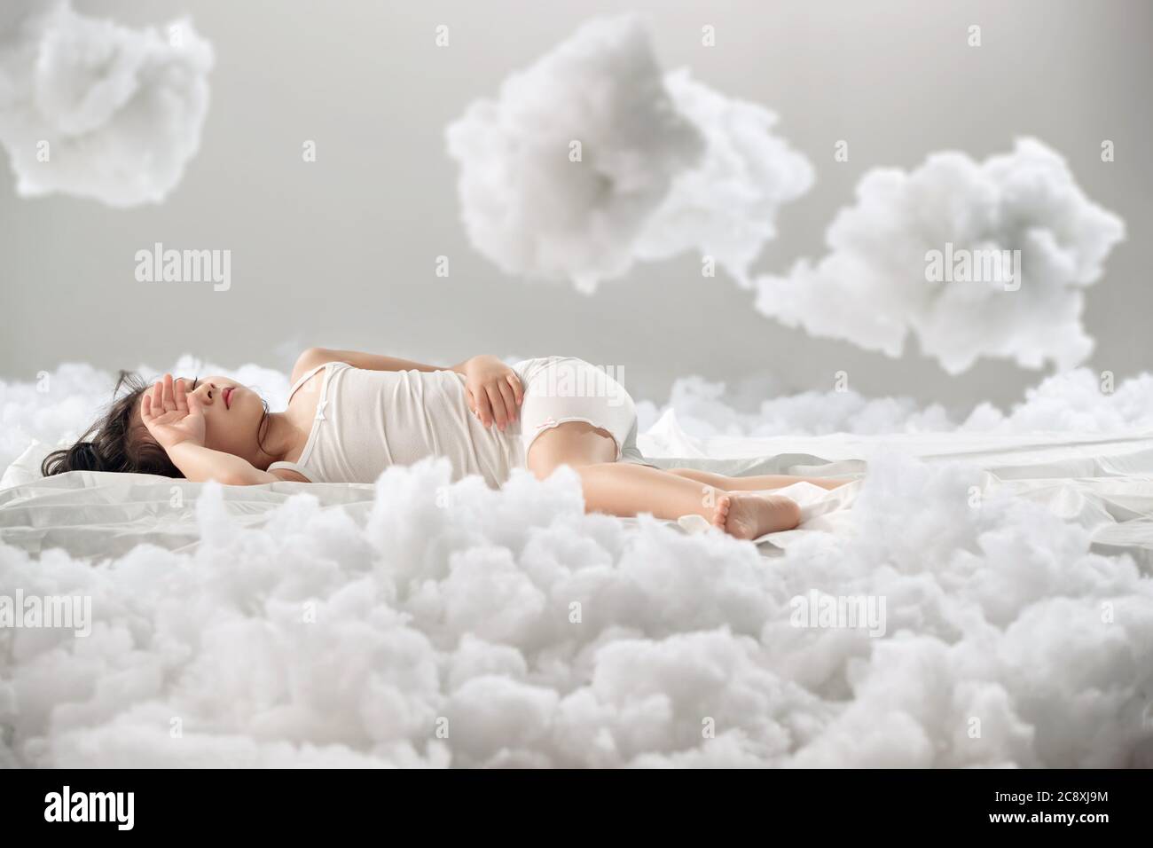 Lovely little girl lying on the cloud Stock Photo - Alamy