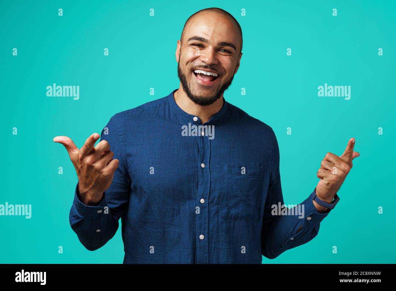 Joyful dark-skinned man laughing against turquoise background Stock Photo