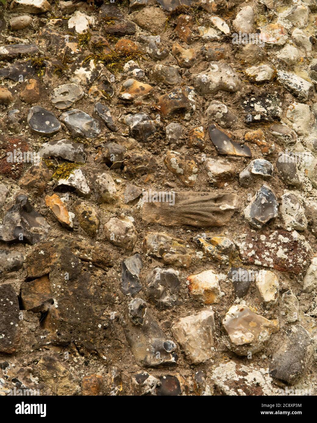 Medieval flint stone wall texture with recycled masonry from earlier buildings Stock Photo