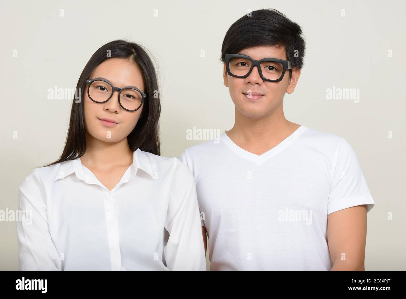 Portrait of young Asian couple together against white background Stock ...