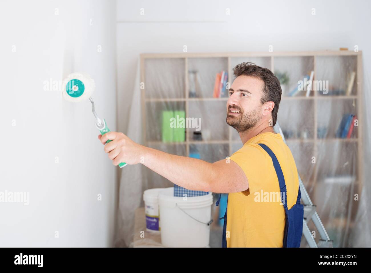 Professional painter portrait whitewashing the wall Stock Photo