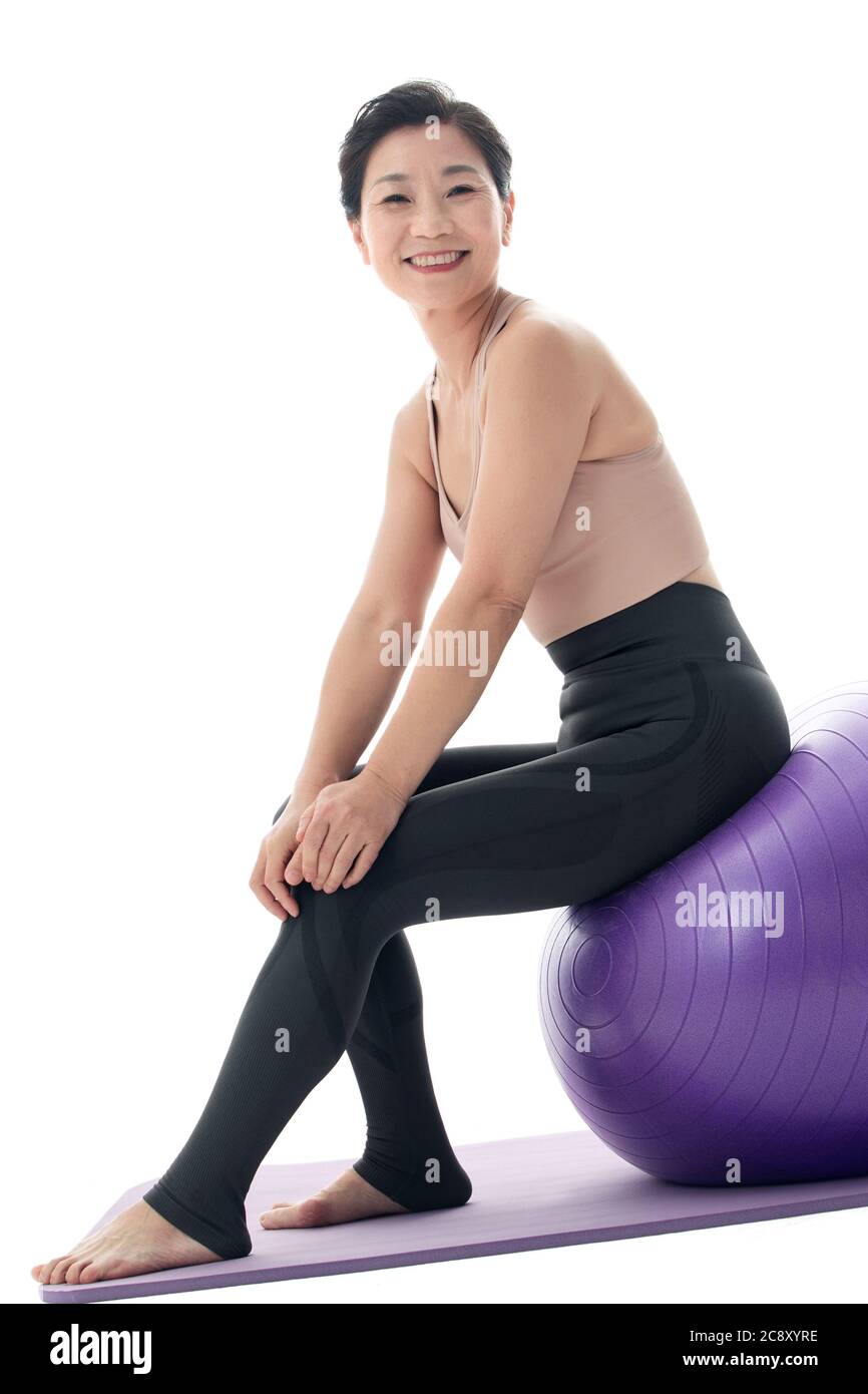 Middle-aged women sitting on a yoga ball Stock Photo