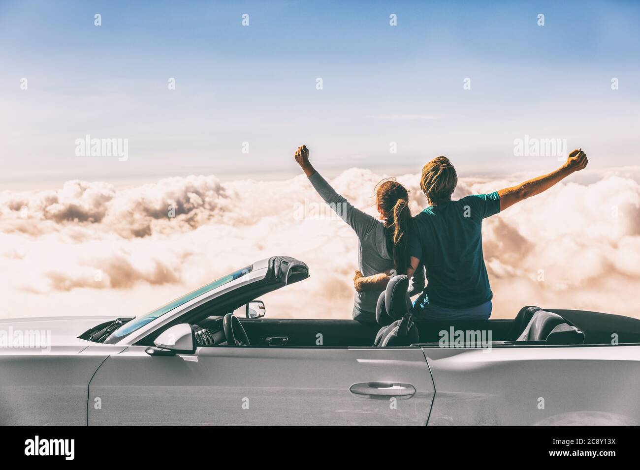Happy car road trip couple freedom on summer travel vacation driving convertible sports car feeling excited winning free Stock Photo