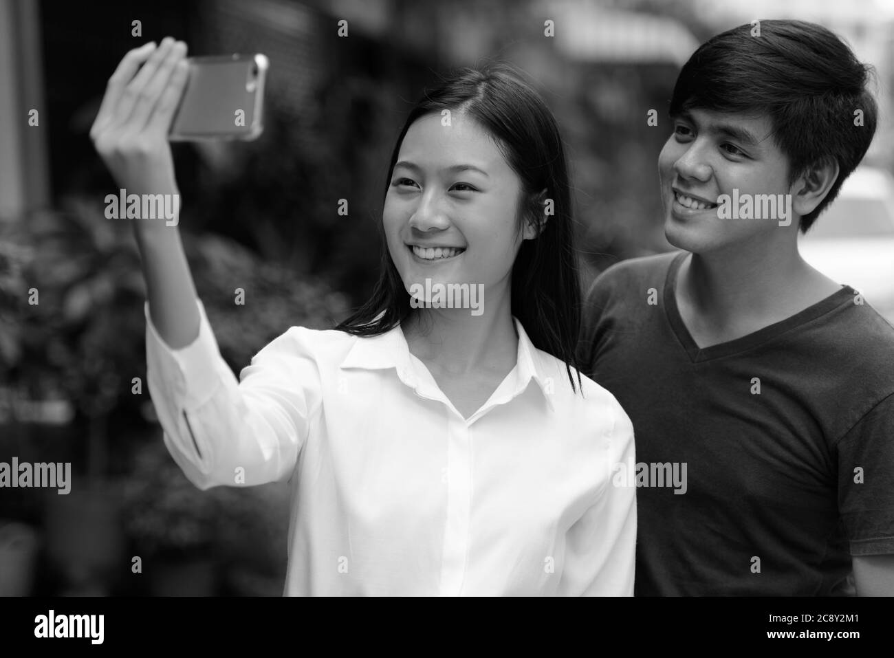 Portrait of young Asian couple together outdoors in black and white Stock Photo