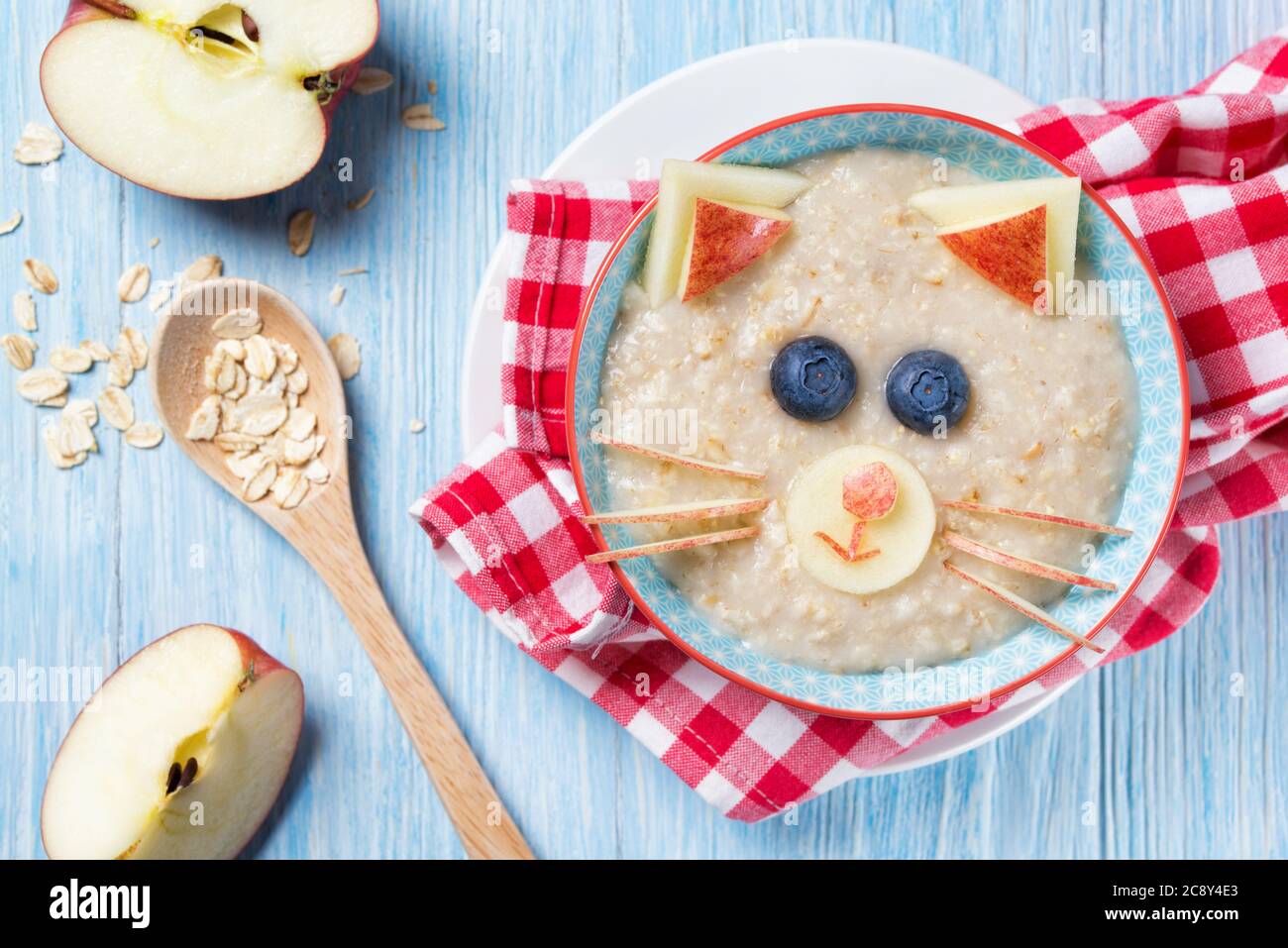 Funny oat porridge with cat, kitten face made of fruit and berries