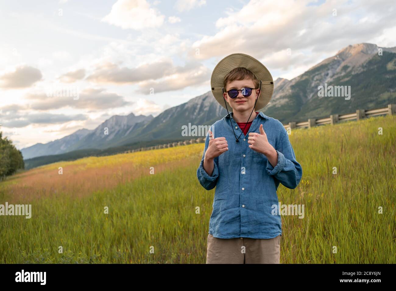 Happy Teenager Boy looking at camera with thumbs up as concept of active living lifestyle and summer outdoor hiking. Stock Photo