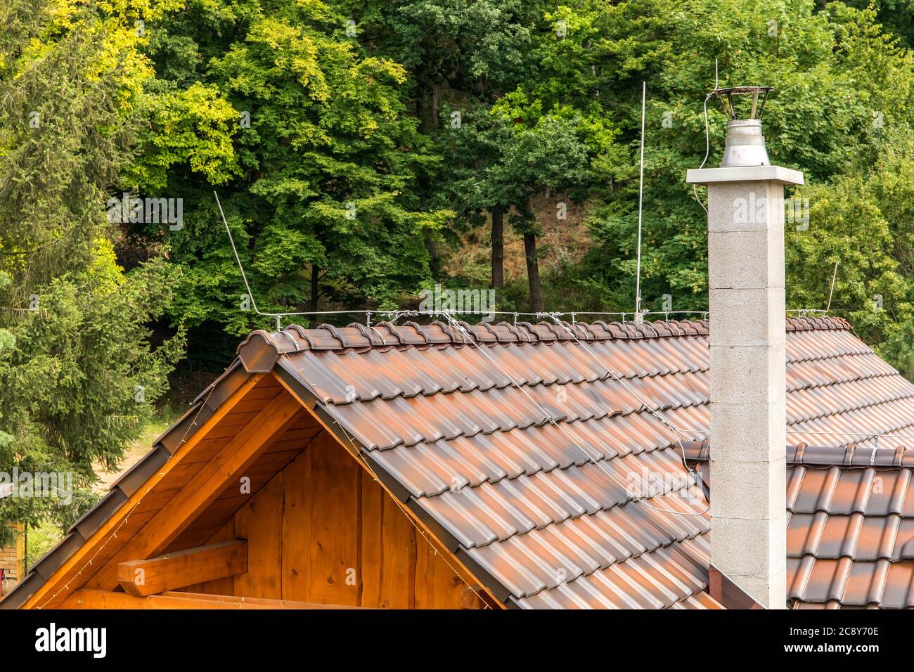 The roof of a family house with a chimney and a lightning conductor