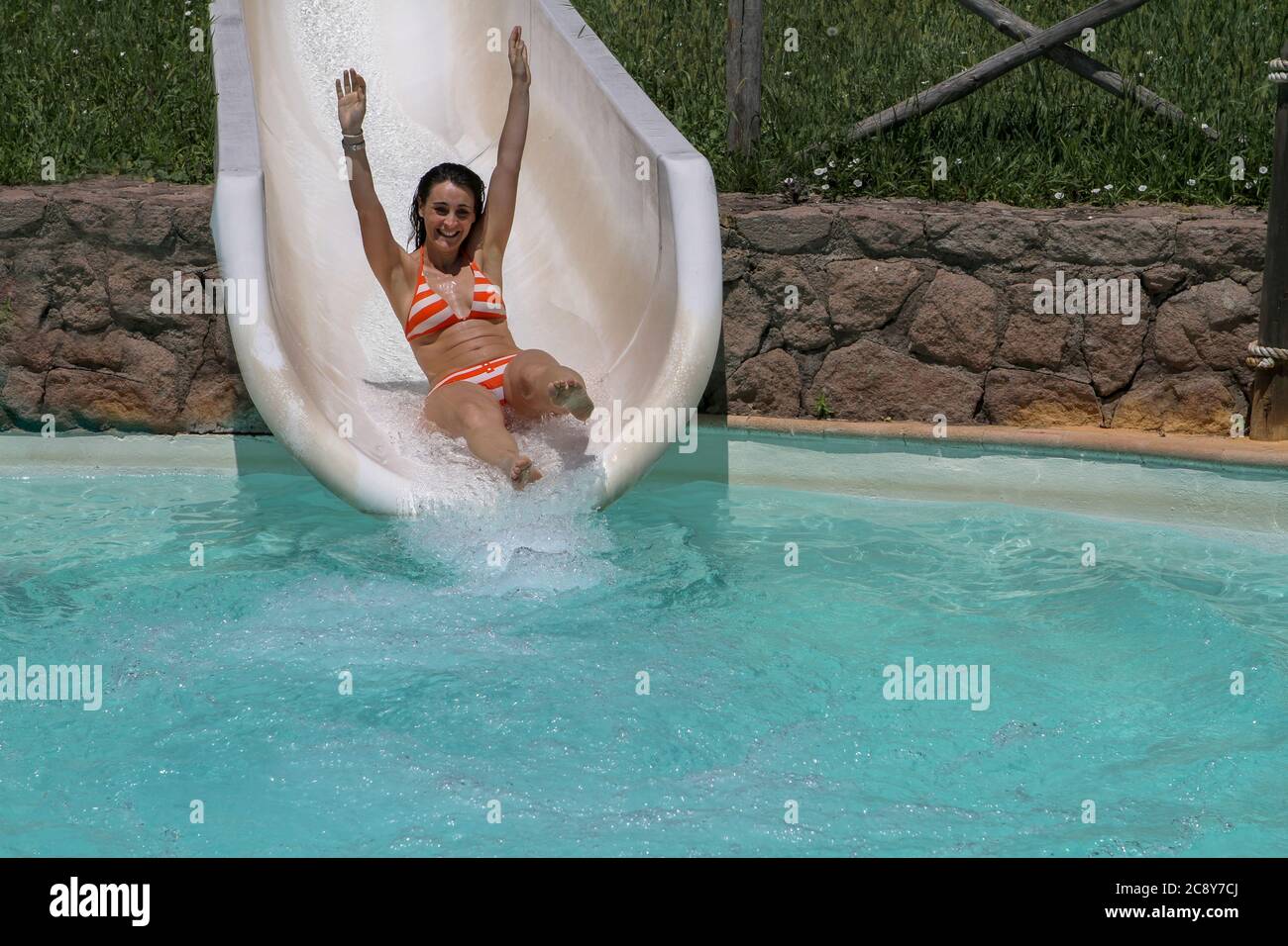 Girl in bikini having fun when falling down water slide in water park Stock  Photo - Alamy