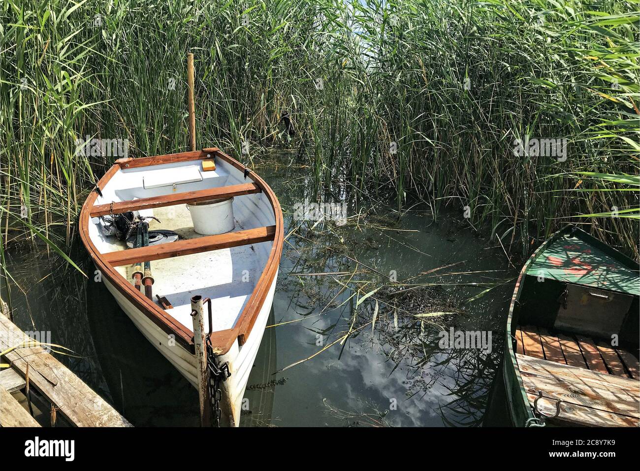 Two fishing boats dock at the footbridge in the reeds of Lake Balaton