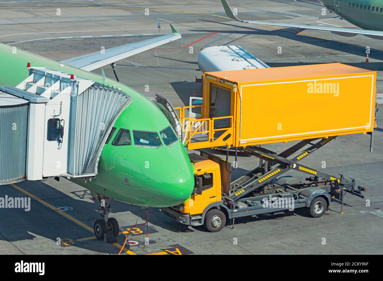 Yellow truck next to a passenger plane, pre flight service airport Stock Photo